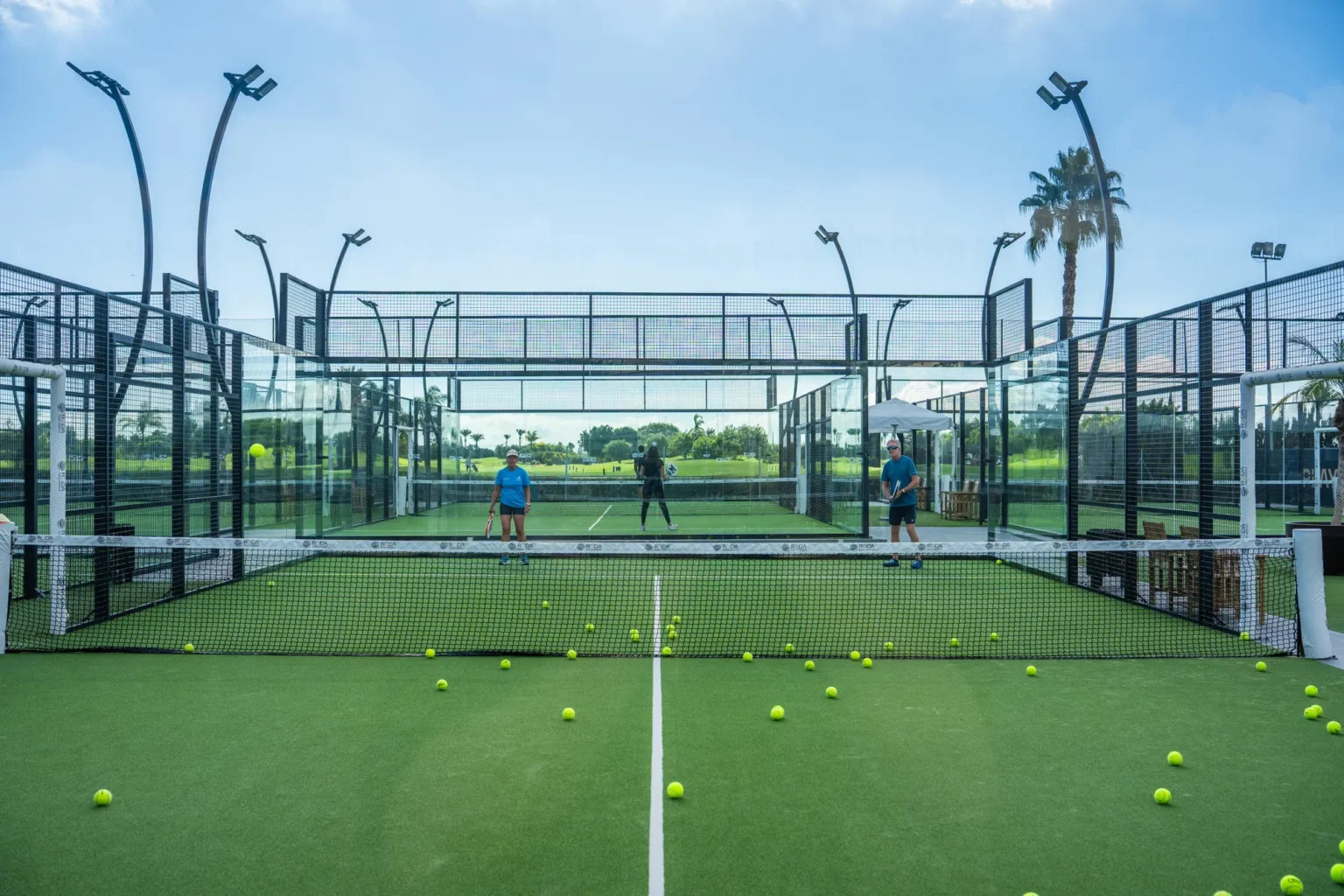 Glass court with balls on the artificial grass